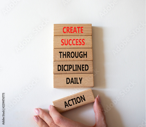  Concept words create success through disciplined daily action on wooden blocks. Businessman hand. Beautiful white background. Business concept. Copy space.