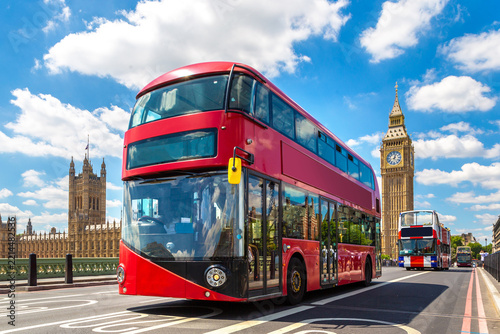 Red double decker bus on Westminster Bridge with Big Ben clock tower and Palace of Westminster in London, England, UK