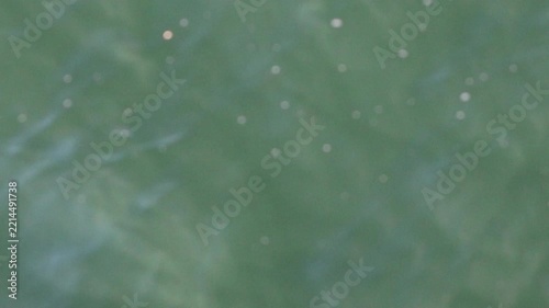 Abstract green water surface of the zêzere river with sparkles of sunlight