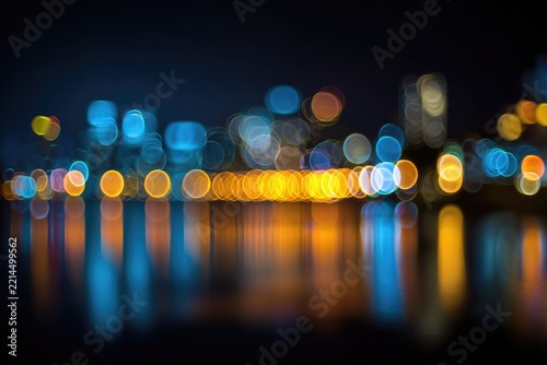 Night cityscape reflected in water, blurred lights