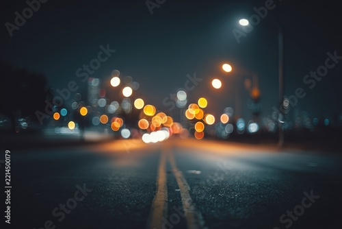 Night road, blurred city lights, dark asphalt