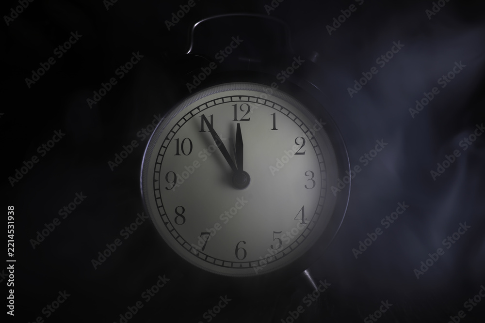 Fototapeta premium Vintage Analog Alarm Clock in Dim Light with Smoke, Emphasizing Time and Mystery