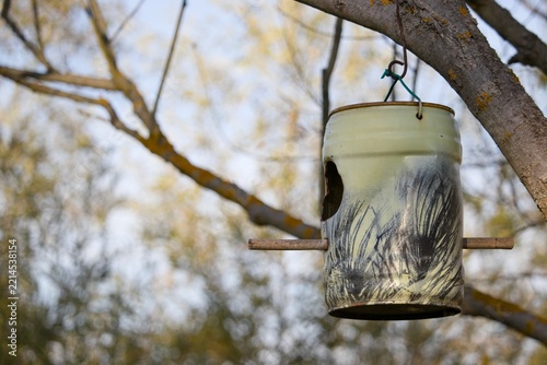 DIY handmade bird feeder hanging on tree branch outdoors