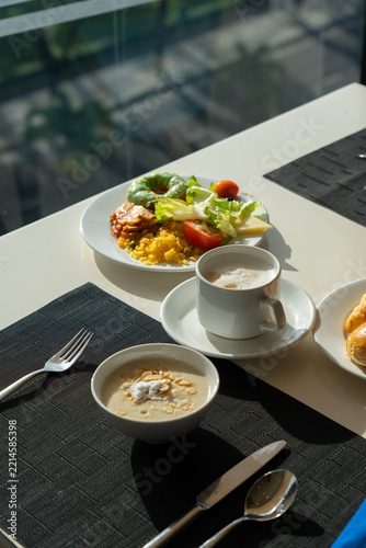 A Beautifully Arranged Breakfast Table with Delicious Plates of Food, Including Fresh Salad, Soup, and Coffee Set Against a Bright Window View