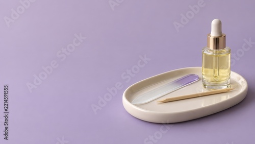 Golden Cuticle Oil With a Glass Nail File on a White Manicure Tray