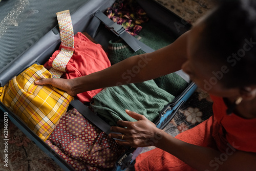 Woman putting clothes into suitcase carefully
