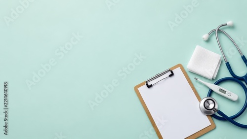 Medical Clipboard with Stethoscope and Thermometer on a Mint Background