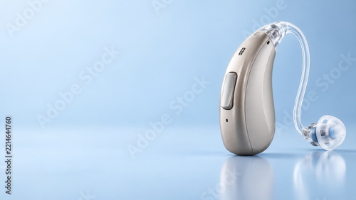 Silver Hearing Aid with Clear Tubing and Earpiece on a Pale Blue Surface