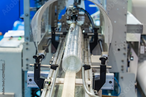 Stack of polypropylene cup on conveyor belt of automatic plastic injection molding machine,automated technology concept
