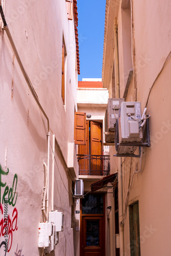 Narrow old town alley with air conditioning units and wooden shutters