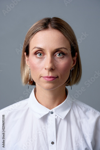 Professional Female Portrait Headshot Looking Confident in White Shirt on Neutral Gray Background