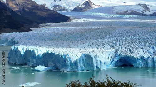 Aerial drone footage of Perito Moreno Glacier in Patagonia, Argentina, showing massive blue ice wall and turquoise water