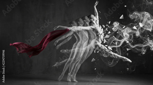 Ballerina performing ballet movement transforming into ceramic porcelain fragment particle with red silk ribbon flowing inside dark studio space representing artistic creative dance metamorphosis