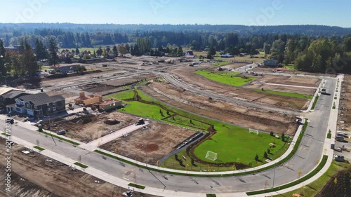 Aerial drone shot circling a new suburban residential construction site in mid construction phase