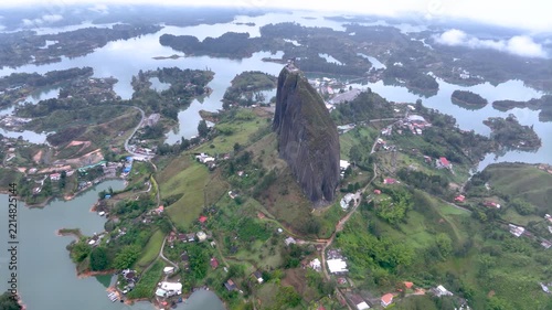 Guatapé and Iconic Piedra del Peñol Surrounded by Reservoir Islands and Mountains in Colombia. Establishing Shot. Aerial View.