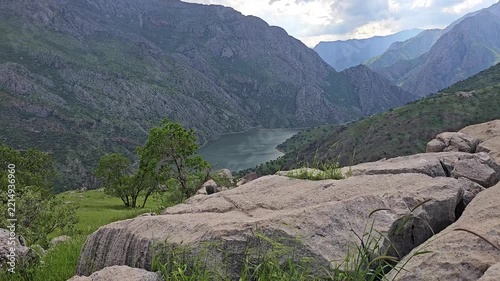 Calm lake in a steep mountain valley, with large boulders and grass swaying in the gentle wind and tree leaves rustling under a cloudy sky.
📍 Hawraman, Sarvabad, Kurdistan 