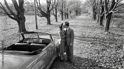 Romantic Vintage Kiss Beside Classic Car in Autumn