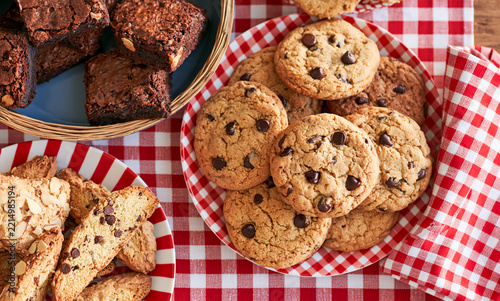 a cozy bakery table with a spread of chocolate chip cookies, brownies, and almond biscotti, copyspace on the sides