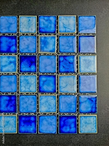 Abstract geometric background featuring a grid of glossy blue ceramic mosaic tiles