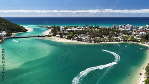 Aerial drone footage of the busy creek beach at Tallebudgera on a summer day, Gold Coast, Queensland Australia