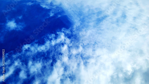 Vibrant blue sky with soft white clouds texture nature background photo