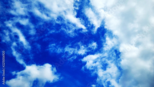 Dramatic deep blue sky with bright white clouds spread natural background photo