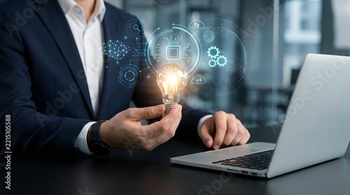 Businessman holding a glowing light bulb with digital technology