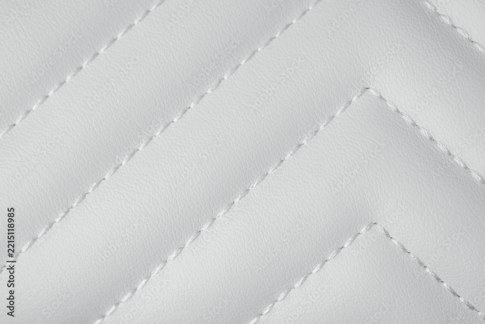 Fototapeta premium Detailed close up of white quilted leather texture with decorative chevron stitching pattern