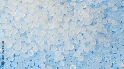 Polymer pellets fall onto rotating granules for medical and industrial manufacturing processes.