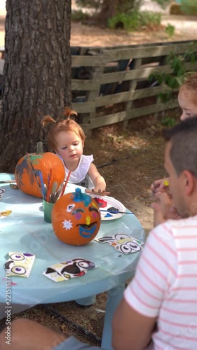 Happy family decorating halloween pumpkins outdoors