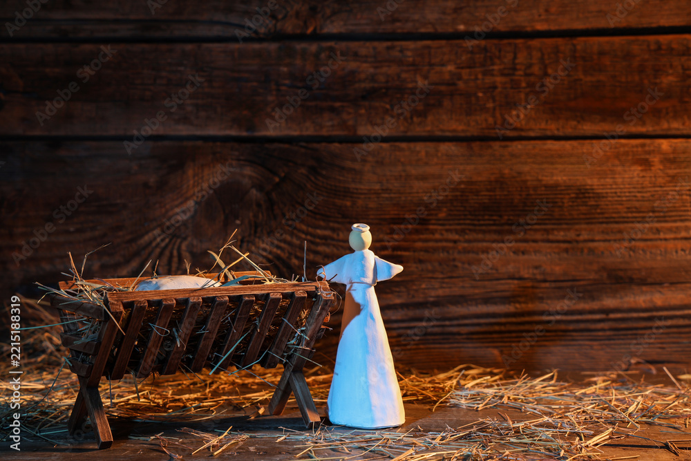 Fototapeta premium Manger with baby Jesus, angel and hay on wooden table