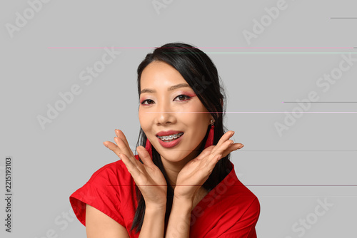 Beautiful young happy Asian woman on grey background. Chinese New Year celebr...