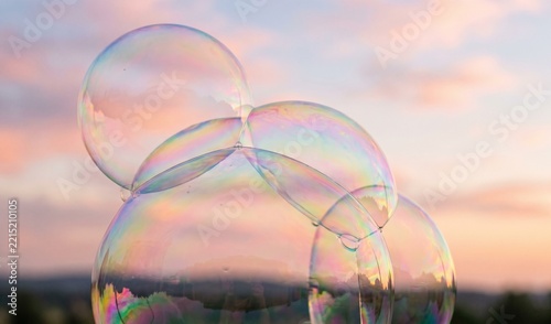 Iridescent soap bubbles on pastel sky