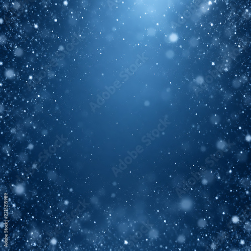 Magical blue winter background with sparkling snow and a bright central light