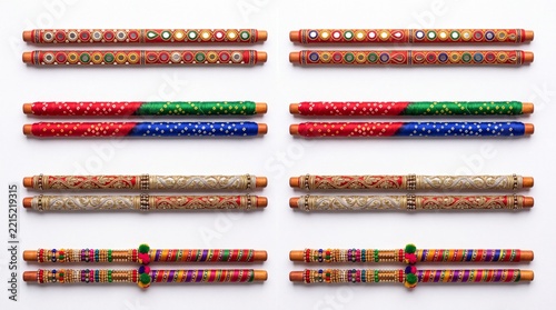 Flat lay of multiple premium dandiya stick pairs with mirror work, bandhani print and zari embroidery arranged in rows