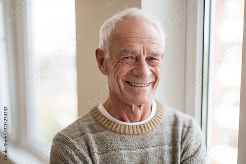 Smiling Senior Man in a Cozy Sweater by a Window