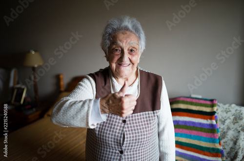 Senior woman giving thumbs up, smiling