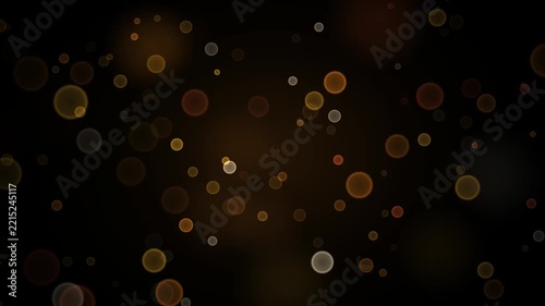 Soft golden circular lights drifting across a dark background with bright glowing orbs moving loop video