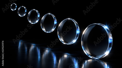 Row of glowing glass rings with blue light reflections on glossy black background in diminishing perspective