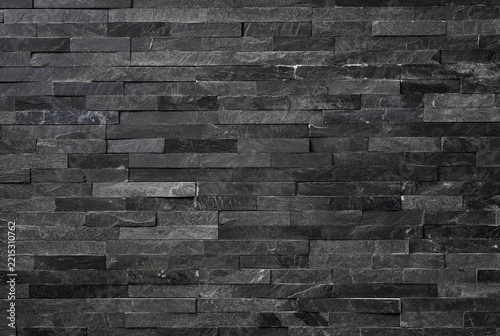 Background of textured natural stone tiles in grey color, modern dark gray slate stone wall cladding texture, elegant grey quartzite brick wall background for contemporary design