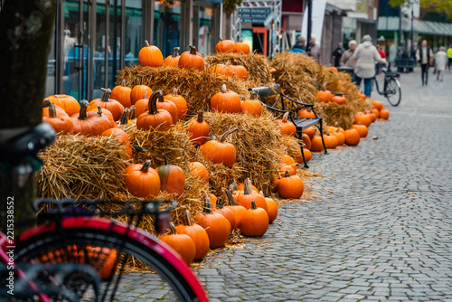 Pumpkins arranged on a street as outdoor Halloween decoration. Warm orange tones and autumn decor create a festive, welcoming spooky-season atmosphere