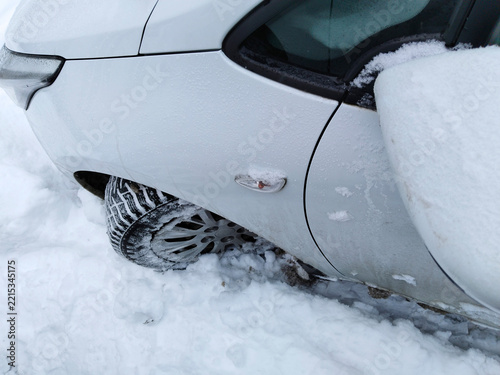 Winter blizzard auto insurance claim accident. Car stuck deep snowdrift traffic collapse. Snow. Vehicle wheels slippery icy road conditions breakdown. White automobile storm damage body shop repair