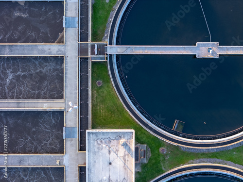 Aerial view of the Bedford Waste Water Treatment facility, featuring large circular clarifier tanks and rectangular aeration basins with concrete walkways in Monroe, Michigan, United States.