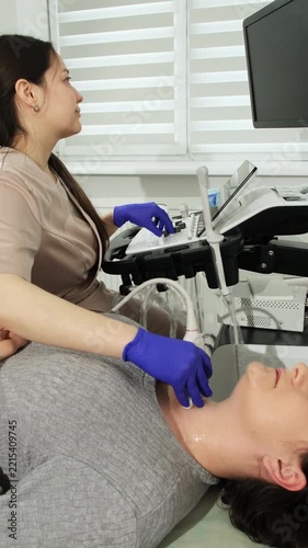 Noninvasive thyroid ultrasound screening supports medical assessment. Doctor examines structural changes linked to endocrine disorders vertical shot