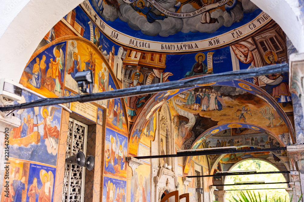 Fototapeta premium Colorful frescoes decorating arches and walls of St. Joachim Church at Osogovo Monastery in North Macedonia, depicting biblical scenes and saints in Byzantine style