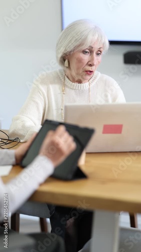 Elderly businesswoman, senior manager, work on laptop in a modern company office . High quality 4k footage