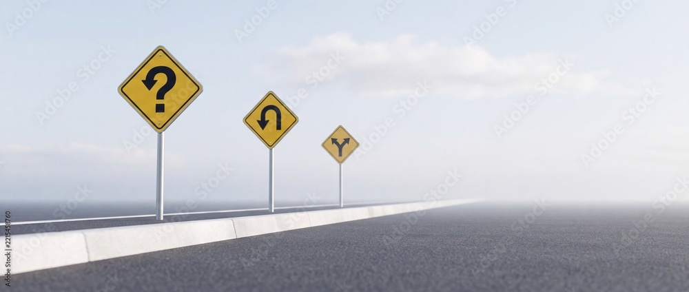 Fototapeta premium Conceptual image of yellow road signs on an asphalt highway representing uncertainty and decision making with a U-turn question mark symbol and a fork in the road under a misty sky.