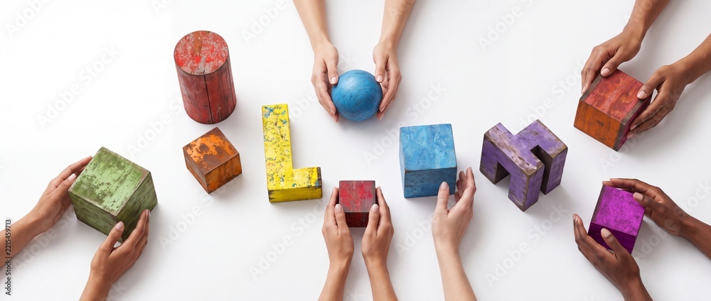 Fototapeta premium Top view of diverse hands arranging colorful distressed wooden geometric blocks on a white background, symbolizing perspective shift, creative teamwork, strategy, collaboration, and problem-solving.