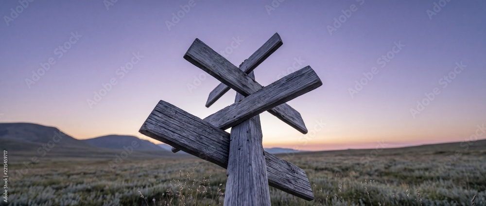 Fototapeta premium Wooden Multi-Directional Signpost at Twilight in a Vast Mountainous Tundra Landscape, Conceptual Image of Navigation, Choice, and Adventure Exploration in the Remote Wilderness at Dawn.