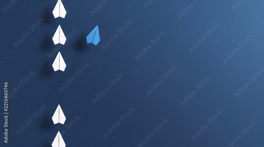 Fototapeta premium Blue Paper Plane Changing Direction From White Ones on Dark Blue Background, Representing Leadership, Innovation, Business Success, Uniqueness, and Thinking Outside the Box Concept